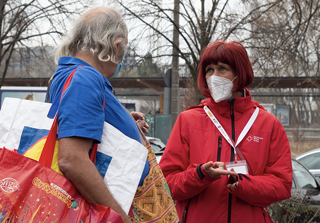 DRK-Mitarbeiterin spricht mit Obdachlosem