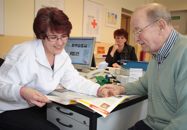 Ärztin in Gespräch mit älterem Patienten